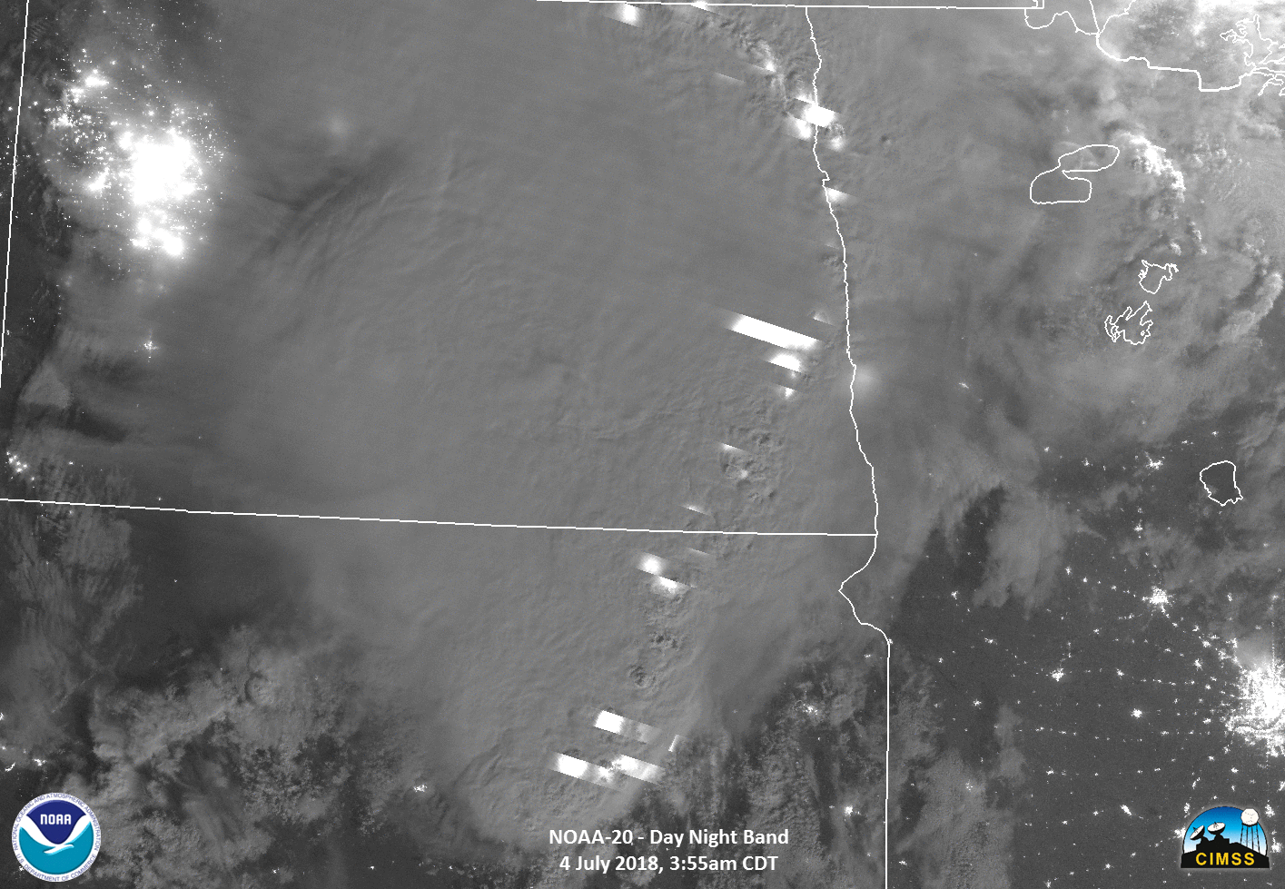 An animation flips between two images of a major storm system in North and South Dakota. The first shows the storm in infrared, red in the middle to indicate colder, more high-intensity areas, spreading out to blue, where the storm is warmer and less intense. The second shows the storm in grayscale in the Day-Night Band. Several white streaks indicate lightning strikes.