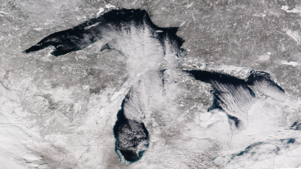 A true-color image of the region around the Great Lakes shows snow and ice covering some of the lakes and most of the surrounding land.