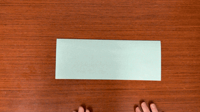 Animation of hands folding a piece of paper in half.