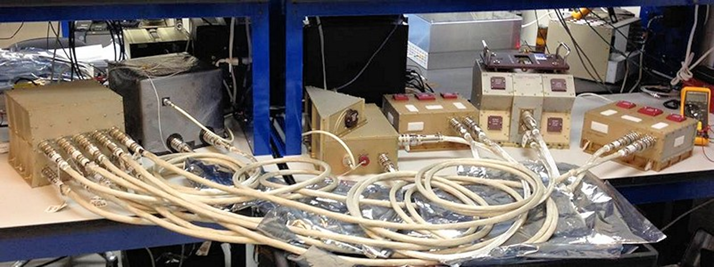 Several devices sitting on a table with multiple white cables.