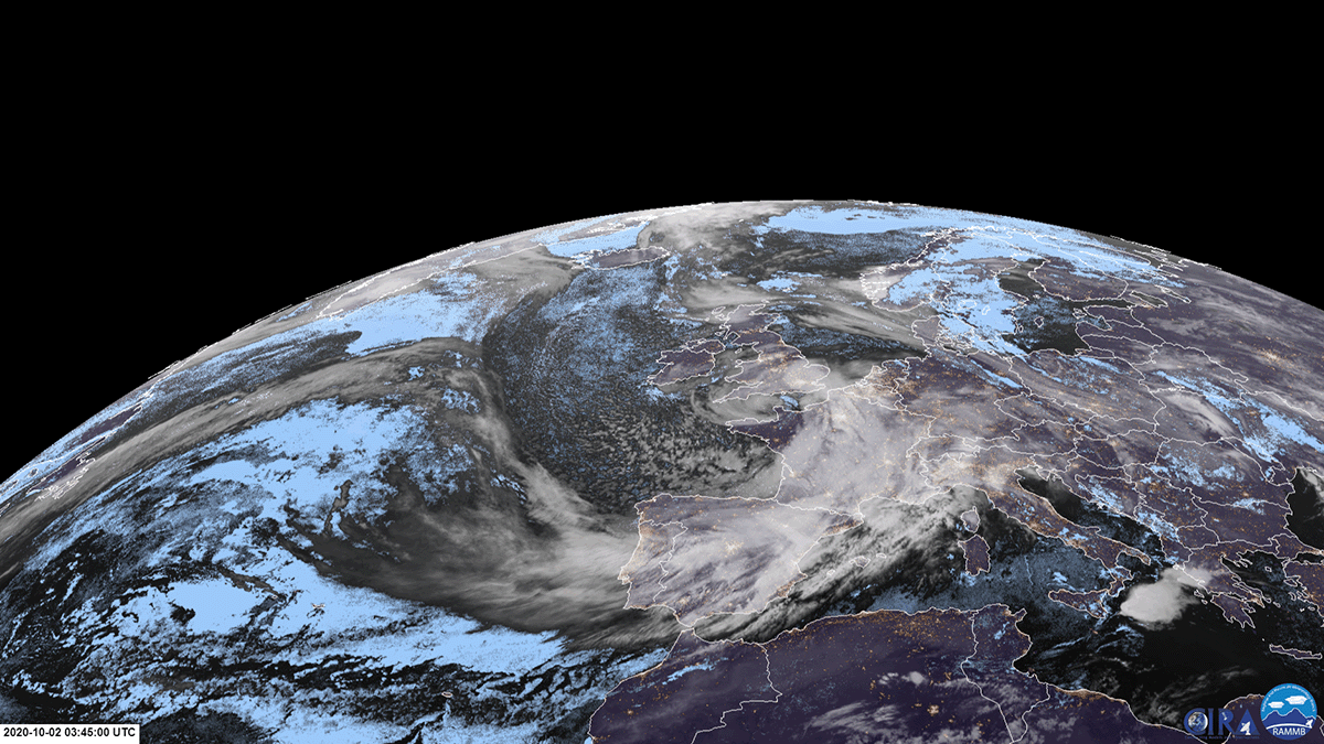 White swirl of tropical storm over brown/green land in the daytime imagery and city lights static background in the nighttime imagery. 