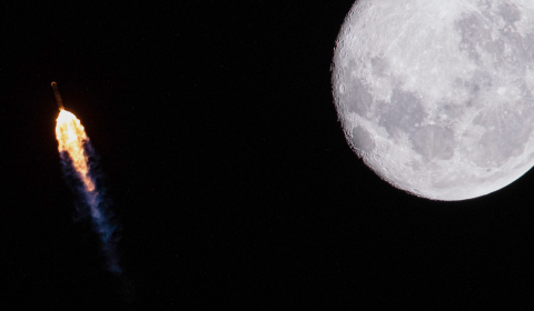 Night photo of a rocket blast next to the Moon.