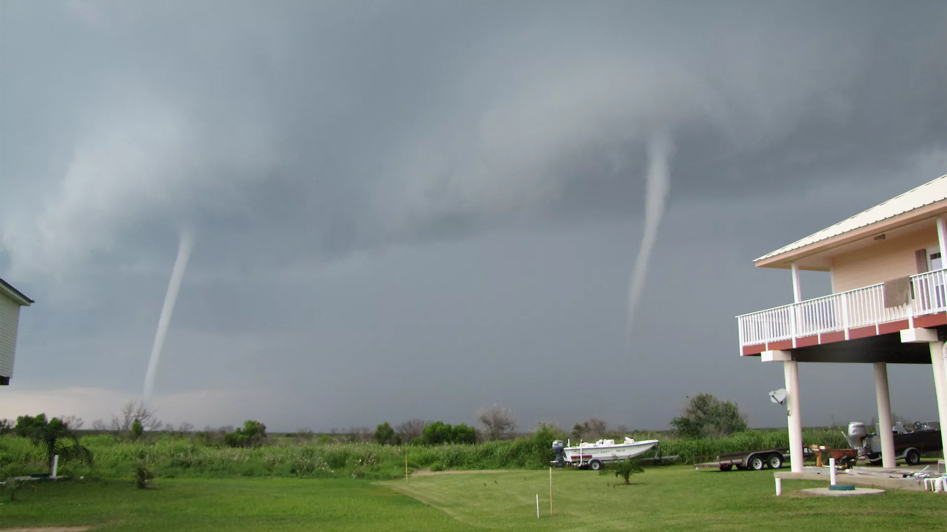 Two tornadoes making landfall near a house