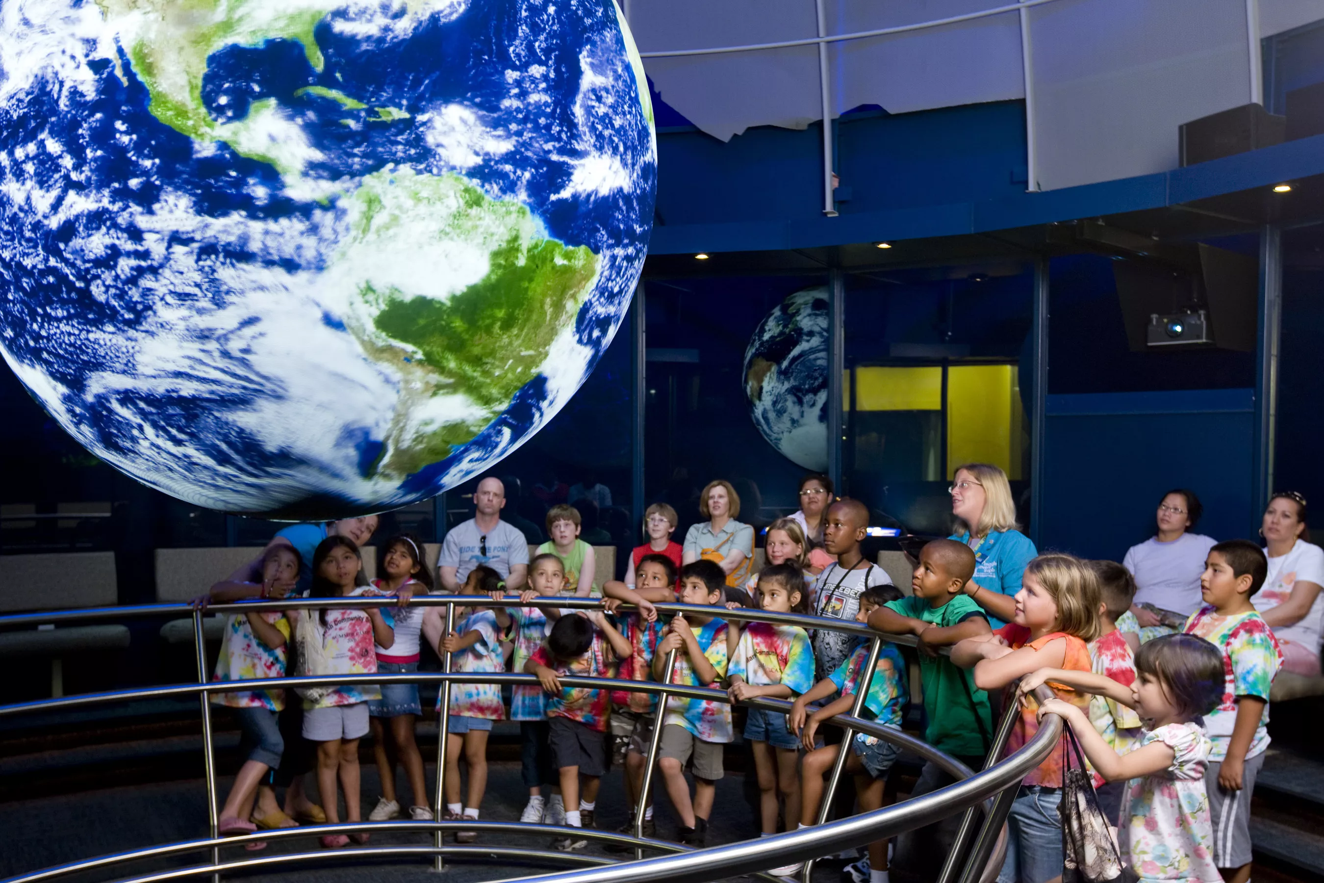 A group of children watches a Science on a Sphere presentation.