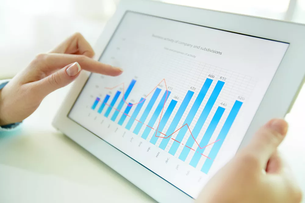 Image of a bar graph on an Ipad with a person holding it