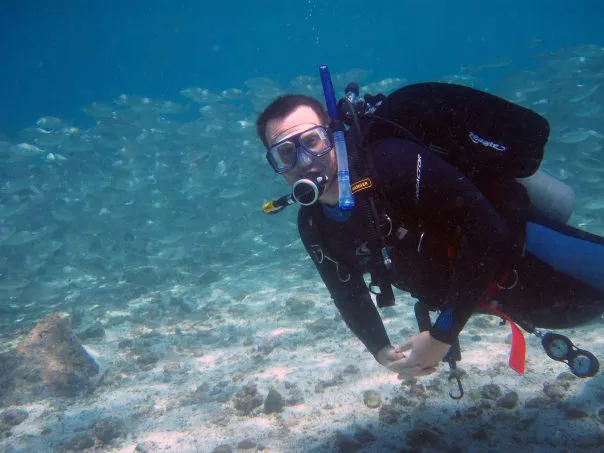 Derek Manzello is shown scuba diving over a coral reef that he is studying.