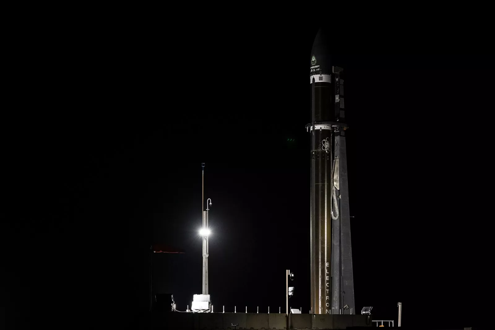 The rocket carrying General Atomics’ GAzelle satellite sits on the pad ahead of launch. It is dark, as the sun has not yet risen.