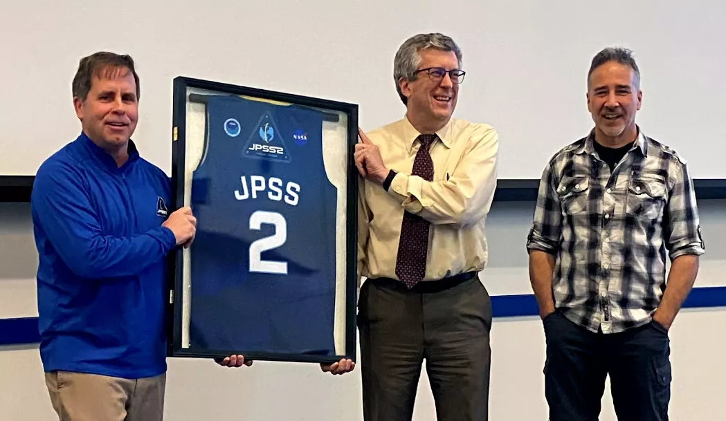 Pictured left to right, JPSS Program Director Tim Walsh presents a JPSS-2 jersey to Thomas Renkevens, NOAA Office of Satellite Products and Operations (OSPO), with JPSS Flight Project Manager André Dress. The jersey symbolizes the retirement of the JPSS-2 name, as NOAA renamed the satellite NOAA-21 after its November 10, 2022 launch.