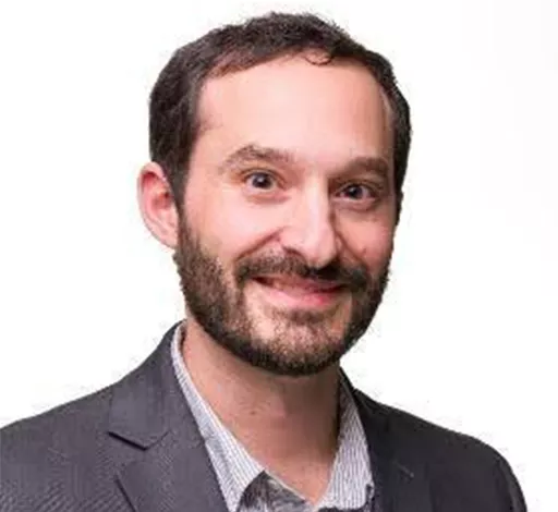 John Cintineo smiling in front of a white background.