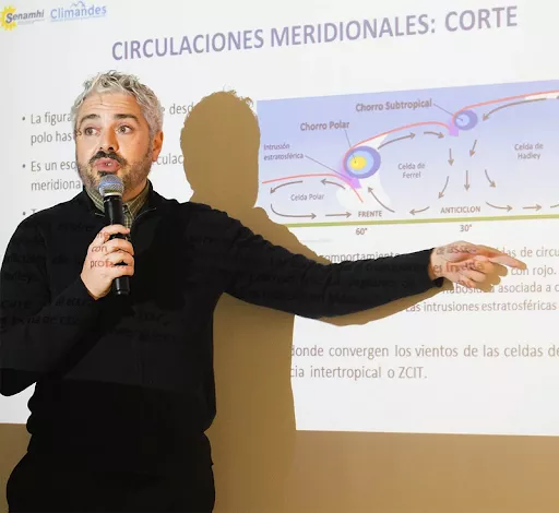 José Manuel Gálvez giving a presentation pointing to a powerpoint on a screen.