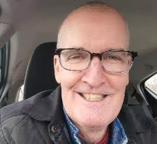 Scott Lindstrom smiling in a car.