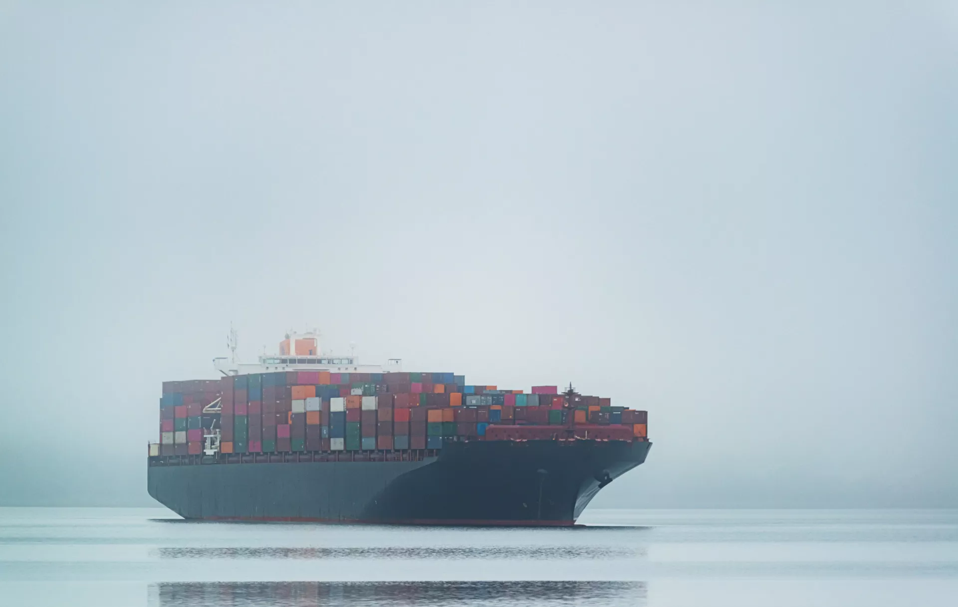 A shipping container ship in fog on the ocean