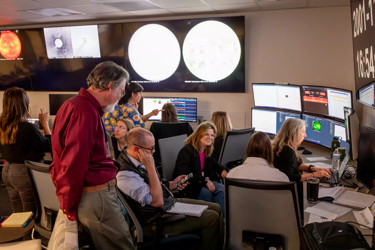 People in front of computer screens talking.