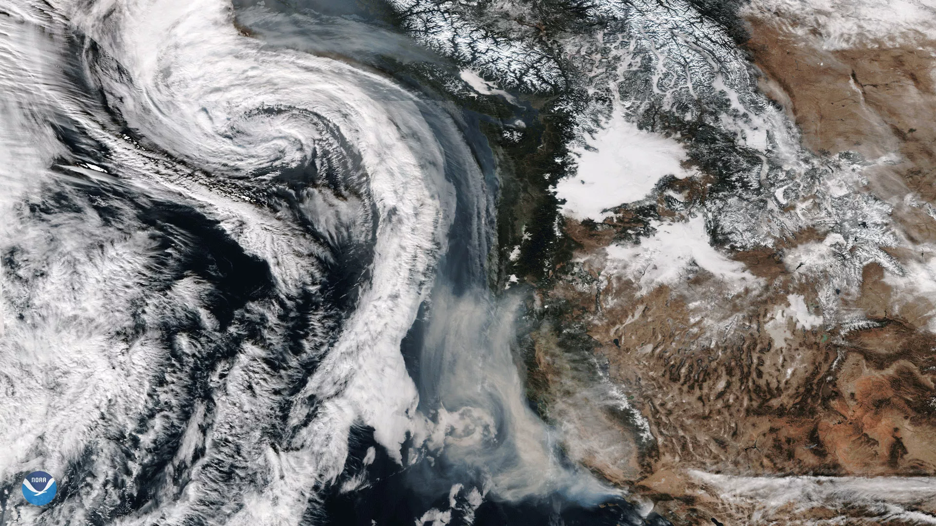 Smoke from California's wildfires being drawn northward into an approaching storm system off the U.S. Pacific Coast on December 11, 2017.