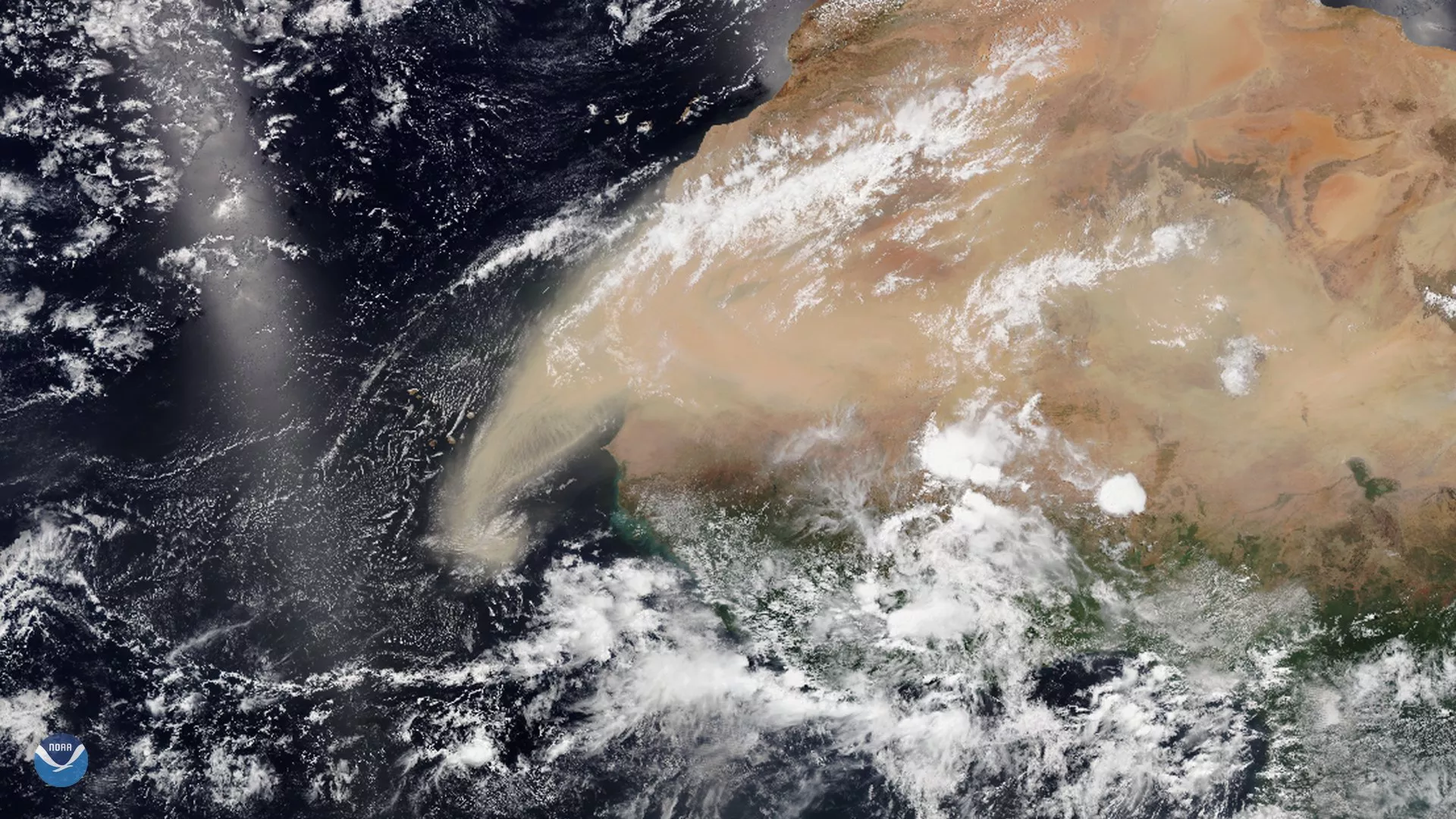 Large brown dust plume mixed with white clouds is seen over Western Africa and extending over the Atlantic Ocean. 