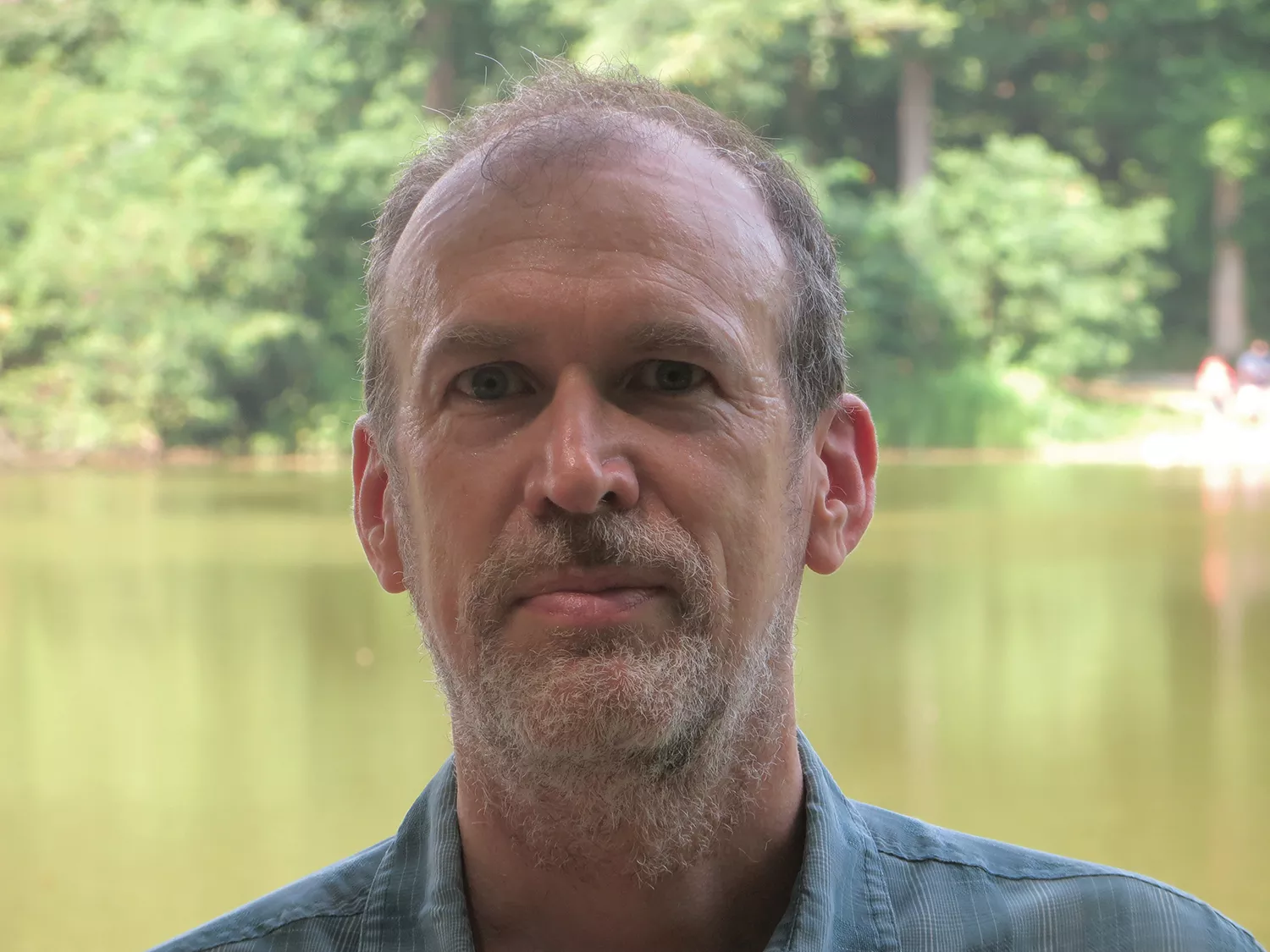 Eric Leuliette in a profile picture, standing in front of pond and forest. 
