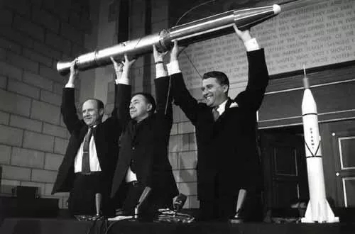 Photograph of William H. Pickering, James van Allen, and Wernher von Braun hold aloft a full-scale model of Explorer I satellite.