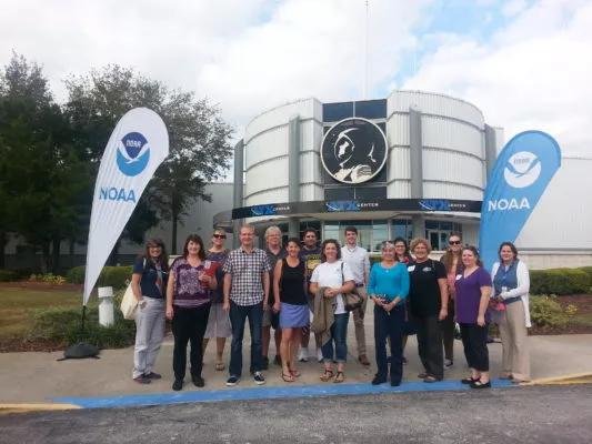 Photo of a group of teachers in front of a building.