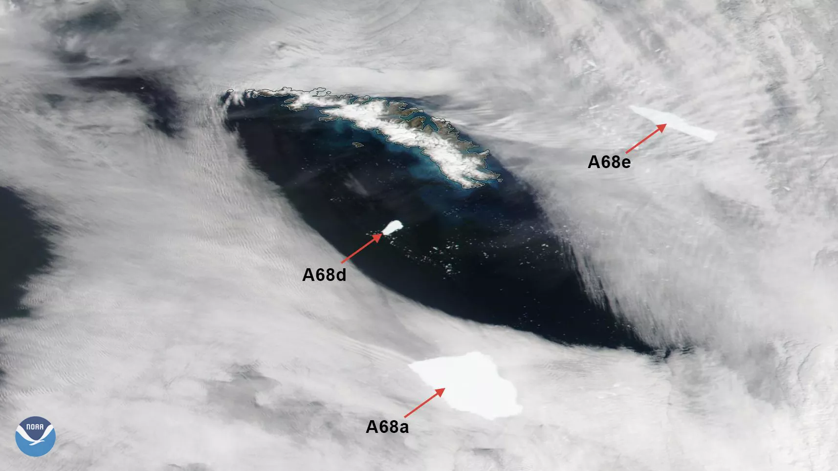 A true color image of South Georgia Island surrounded by clouds and three icebergs
